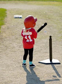 kid holding bat t ball